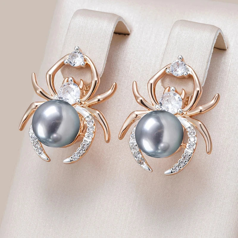 Spider-shaped earrings with pearls and gemstones on a beige background