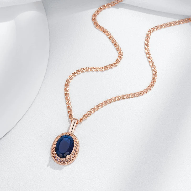 Rose gold necklace with a blue gemstone pendant on a white background