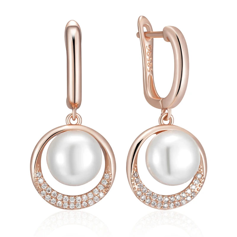 Rose gold earrings with white pearls on a white background