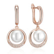 Rose gold earrings with white pearls on a white background