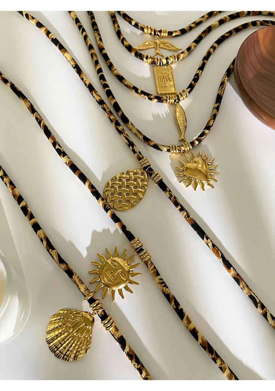 Gold necklaces with various pendants on a white surface