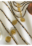 Gold necklaces with various pendants on a white surface