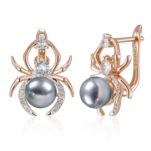 Spider-shaped earrings with gray pearls and rose gold accents on a white background