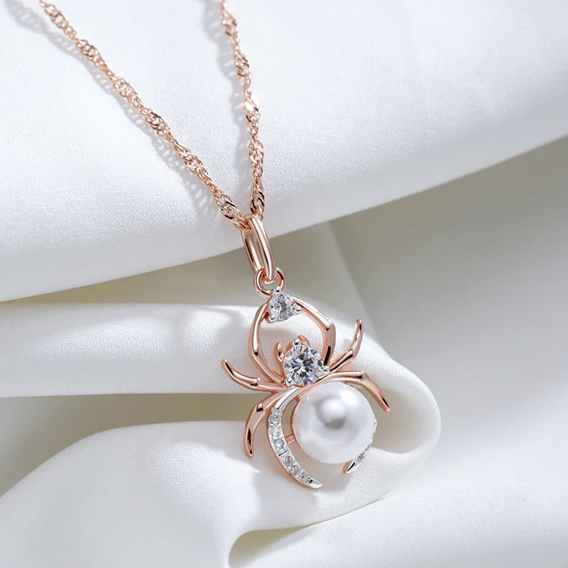 Rose gold spider-shaped pendant with pearl and diamonds on a white background