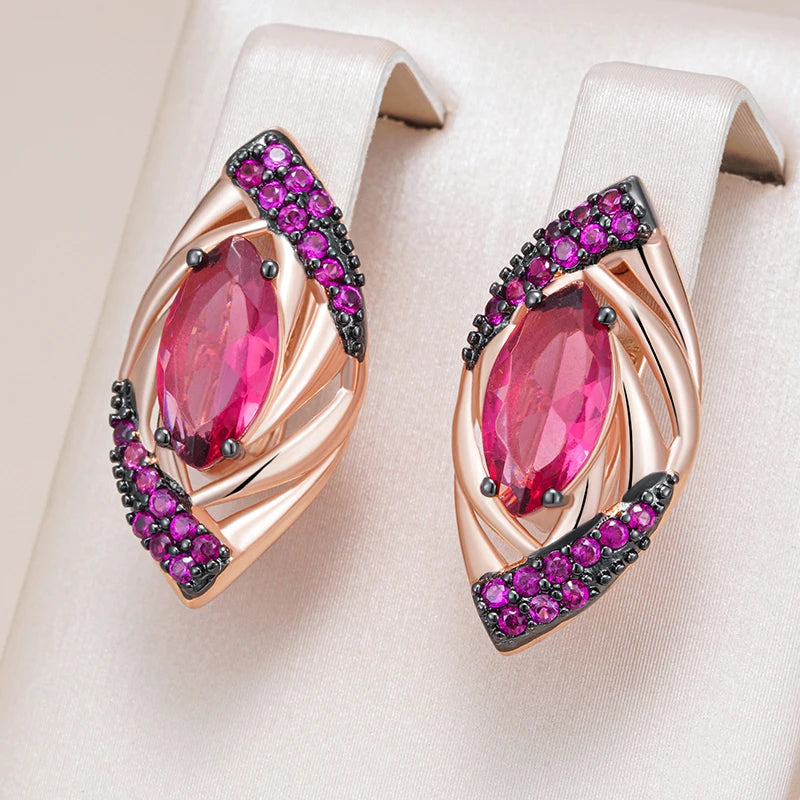 Pair of earrings with pink gemstones and purple accents on a beige background