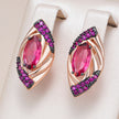 Pair of earrings with pink gemstones and purple accents on a beige background