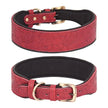 Red leather dog collar with floral embossing and gold hardware on a white background