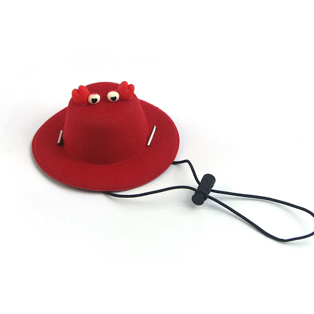 Red pet hat with a face design and a black cord on a white background