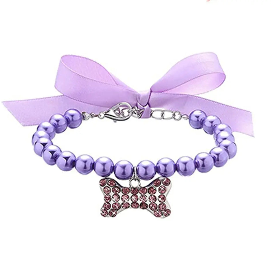 Purple beaded collar with a bow charm and ribbon on a white background