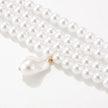 a choker-style necklace made of four rows of small, round white pearls. It has a gold-toned clasp at the back and a single, larger, teardrop-shaped white pearl pendant hanging from the center front.