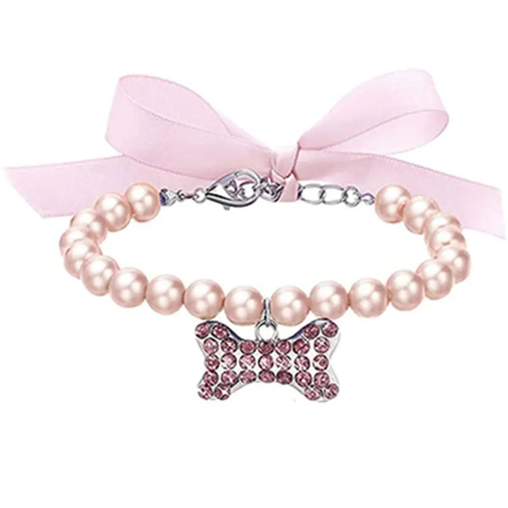 Pearl collar with a pink bow and bow-shaped charm on a white background