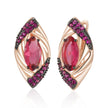 Rose gold earrings with red gemstones on a white background