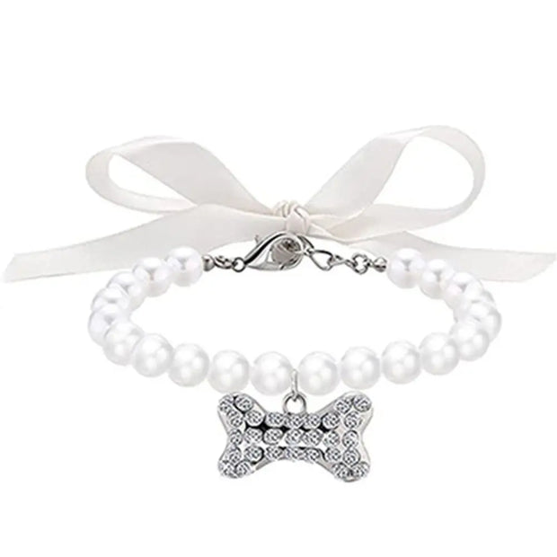 Pearl collar with a bone-shaped charm and white ribbon on a white background