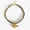 Necklace with tortoiseshell pattern and gold bird pendant on a white background