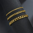 Three gold chain bracelets on a black surface