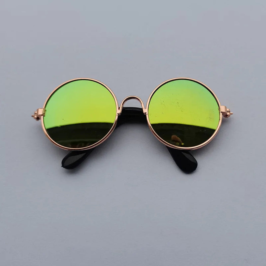 Round sunglasses with green lenses and rose gold frames on a gray background