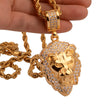 Gold lion pendant necklace held by a hand on a white background