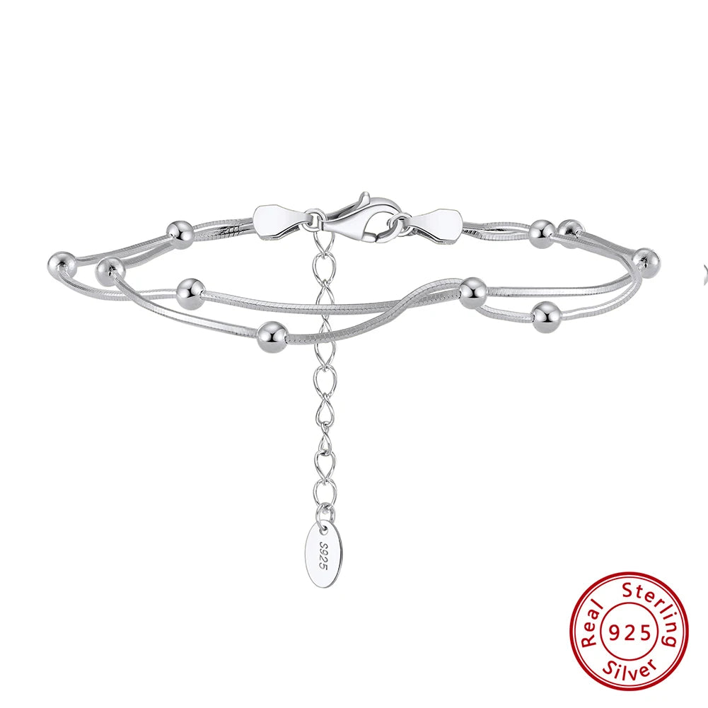 Silver bracelet with a chain tag on a white background, featuring 'Real Sterling Silver' stamp.