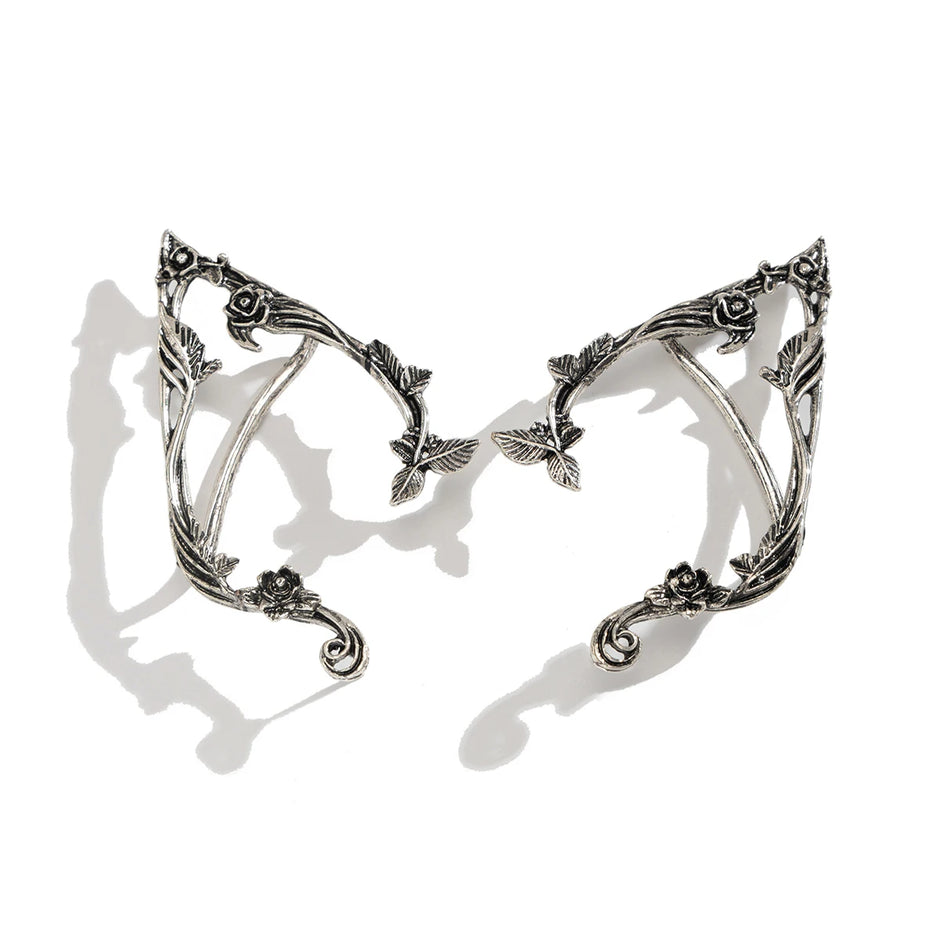 Pair of silver elf ears with intricate designs on a white background