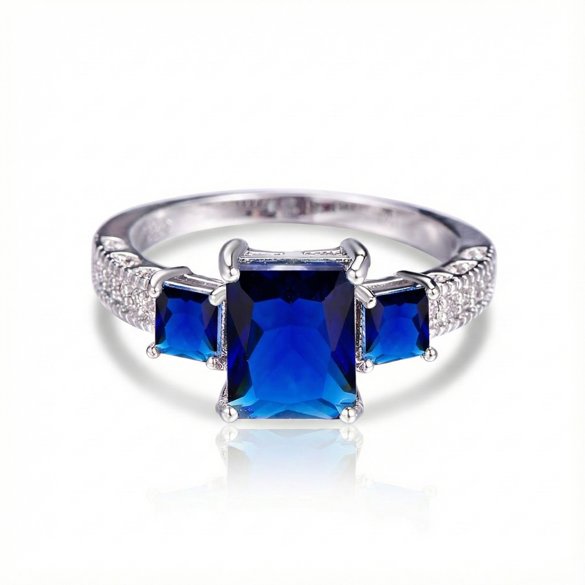 Silver ring with three blue gemstones on a white background