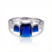 Silver ring with three blue gemstones on a white background