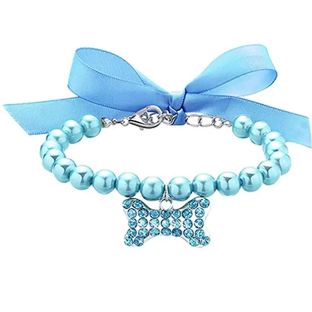 Blue beaded collar with a butterfly charm and blue ribbon on a white background