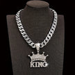 Silver chain necklace with 'KING' pendant on a black stand