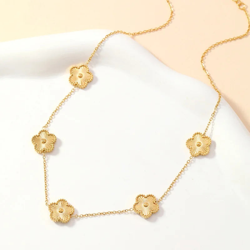 a gold necklace with multiple golden clover-shaped links.