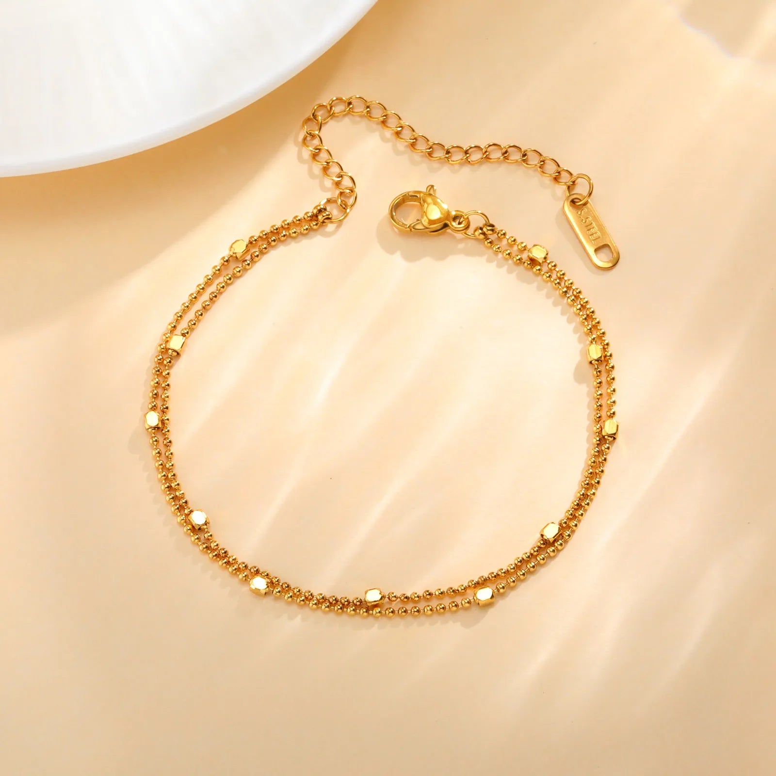 Gold bracelet on a beige background