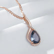 Rose gold necklace with a blue teardrop pendant on a white background