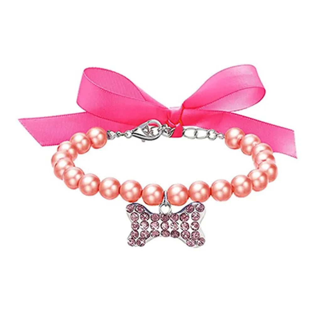 Pink pearl collar with a bow charm and pink ribbon on a white background