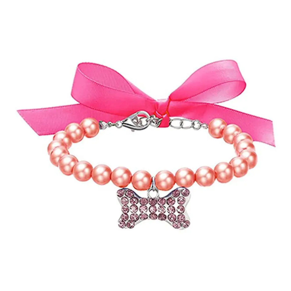 Pink pearl collar with a bow charm and pink ribbon on a white background