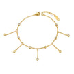 Gold anklet with small beads on a white background