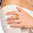 Hand wearing a gold lizard-shaped ring on a white background