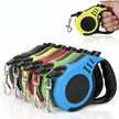 Set of colorful retractable dog leashes with a hand holding one in the top corner.
