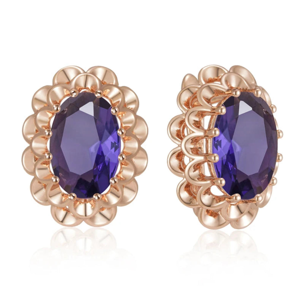 Rose gold earrings with purple gemstones on a white background