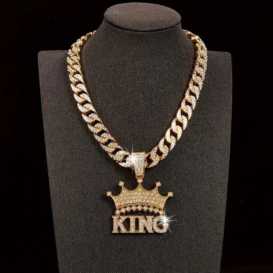 Gold chain necklace with 'KING' pendant on a black stand