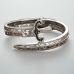 Silver bracelet with intricate designs on a light gray background