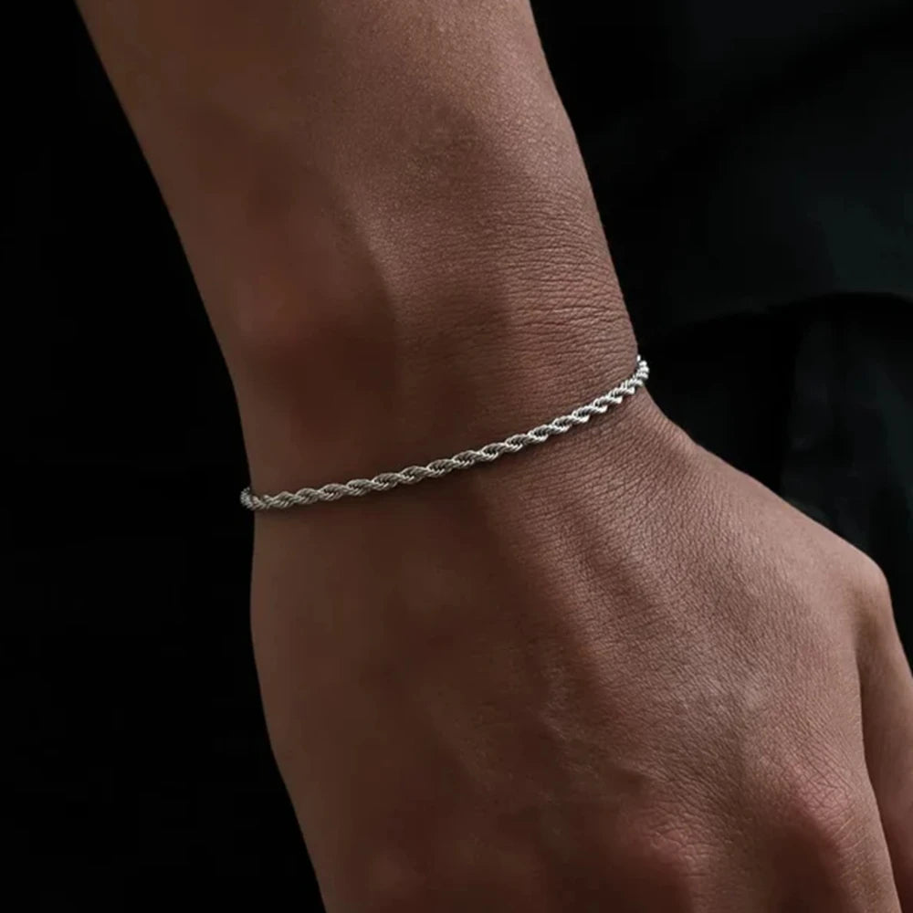 Silver bracelet on a wrist against a black background
