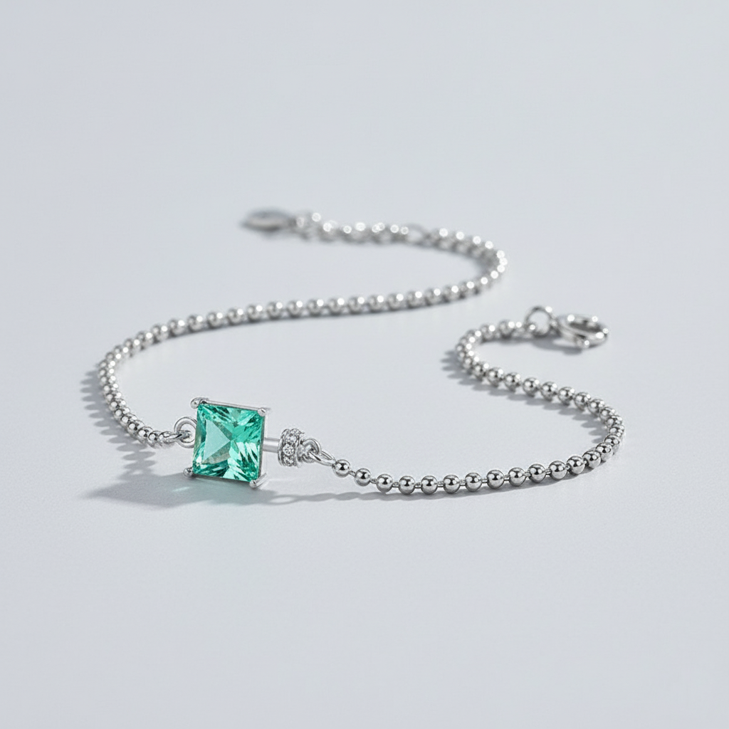 Silver bracelet with a green gemstone on a light gray background