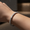 Silver bracelet with diamonds on a wrist against a blurred background