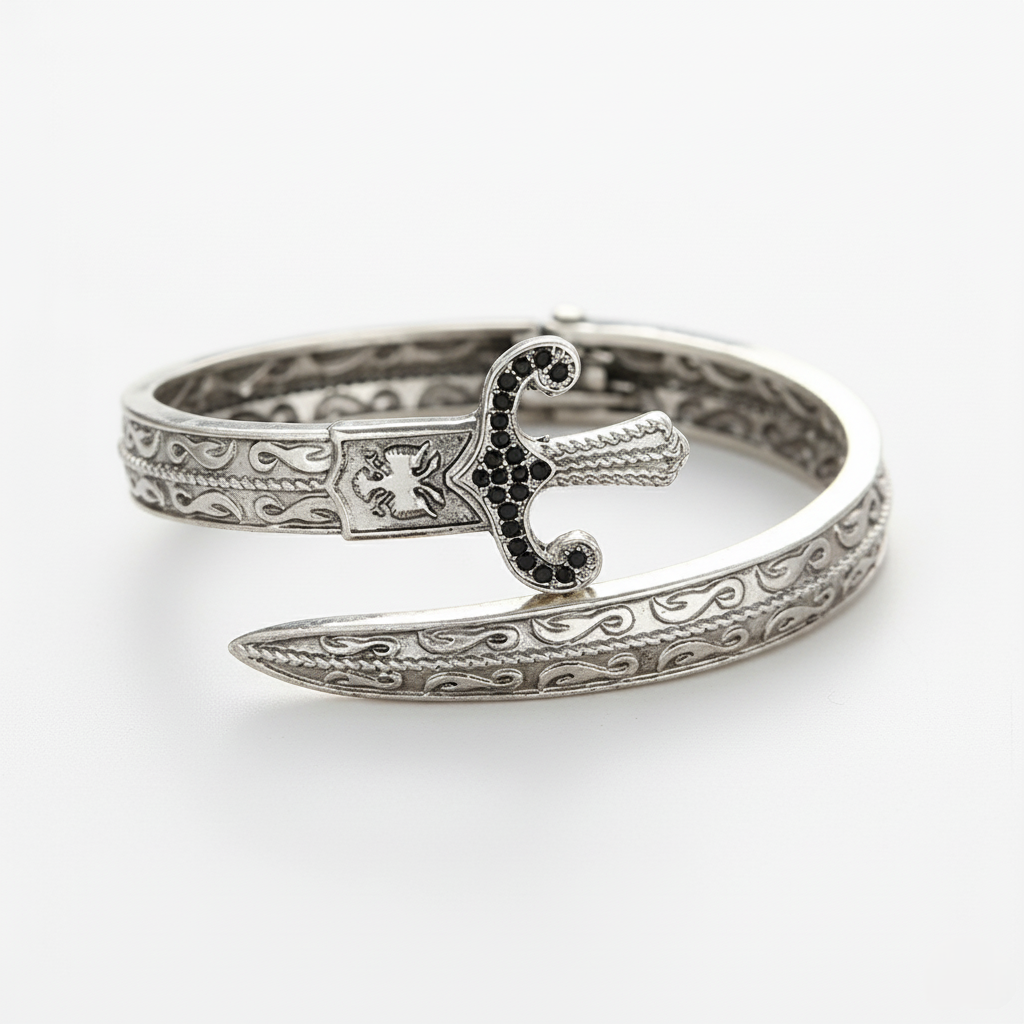 Silver bracelet with intricate design and black gemstones on a white background