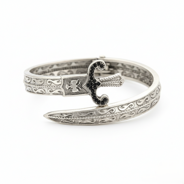 Silver bracelet with intricate design on a white background
