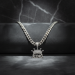 Silver chain necklace with a 'KING' pendant on a dark background