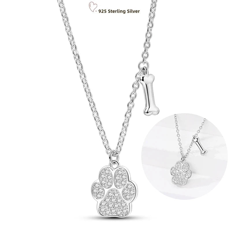 Silver paw print necklace with clear stones on a white background