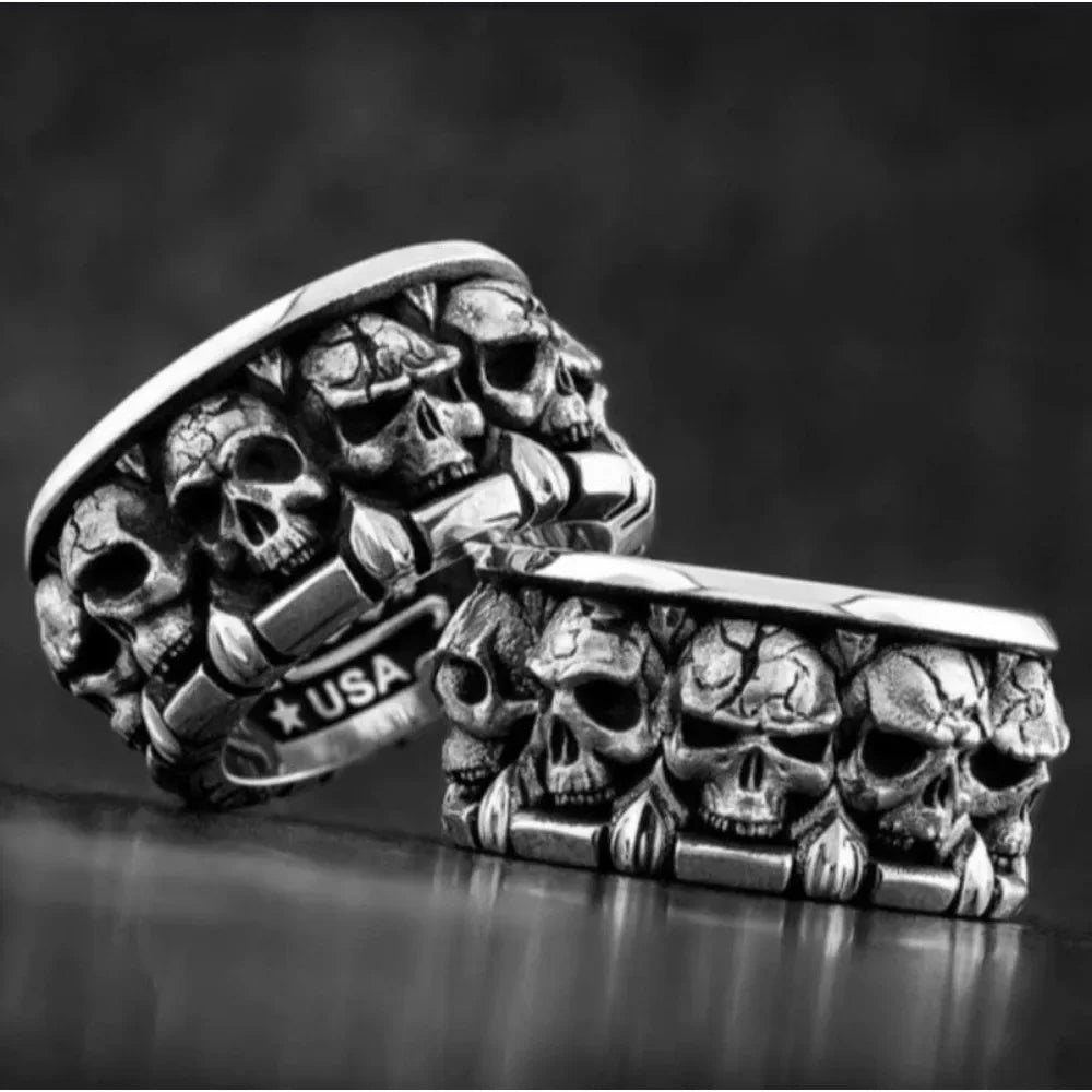 Silver ring with skull design on a dark background