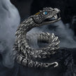 Silver snake-shaped bracelet with detailed design on a dark background