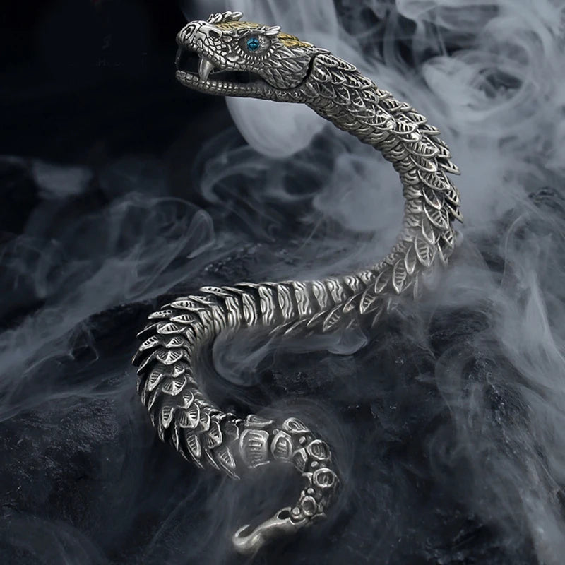 Silver snake-shaped jewelry piece on a dark background with a smoke effect