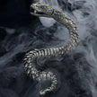 Silver snake-shaped jewelry piece on a dark background with a smoke effect