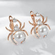 Spider-shaped earrings with pearls and gemstones on a white background